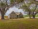 Well maintained home with manicured front lawn framed by large shade trees at 7875 Berry Manor Ln, Edisto Island, SC 29438