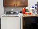Laundry room with front load washer and dryer and wood cabinets at 7875 Berry Manor Ln, Edisto Island, SC 29438