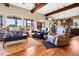 Open living room with vaulted ceilings, wood beams, large windows, and wood flooring at 7875 Berry Manor Ln, Edisto Island, SC 29438