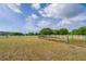 Large yard with white fencing, featuring irrigation system with lush green lawn and trees at 7875 Berry Manor Ln, Edisto Island, SC 29438