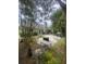 Private backyard oasis offers a stone patio with multiple seating areas and lush landscaping at 1061 Reverend Joseph Heyward Rd, Charleston, SC 29414