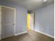 Neutral bedroom with blue walls, tan carpet, and an open doorway at 1061 Reverend Joseph Heyward Rd, Charleston, SC 29414