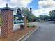Welcoming entrance to Pine Forest Country Club with decorative signage and well-maintained landscaping at 112 Riviera Dr, Summerville, SC 29483
