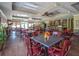 Spacious dining room with tables, chairs, wood floors, ceiling fans, and a bar in the background at 112 Riviera Dr, Summerville, SC 29483