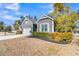 This property features gray siding, well-kept landscaping, an American flag, and an attached garage at 112 Riviera Dr, Summerville, SC 29483
