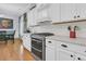 Bright kitchen features white cabinets, subway tile backsplash, stainless steel range, and hardwood floors at 112 Riviera Dr, Summerville, SC 29483