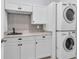 Functional laundry room featuring stacked washer and dryer, white cabinets, and ample counter space at 112 Riviera Dr, Summerville, SC 29483