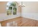 Elegant dining room featuring a large arched window, hardwood floors, and wainscoting for a refined ambiance at 1144 Clearspring Dr, Charleston, SC 29412