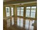Bright living room featuring gleaming hardwood floors and multiple windows overlooking the serene water view at 1144 Clearspring Dr, Charleston, SC 29412