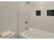 A bathroom featuring white tiling with dark green accent tile and shower head at 1172 Dawn Dr, Charleston, SC 29412