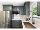 Modern kitchen with stainless steel appliances, dark green cabinets and light countertops, providing a sleek look at 1172 Dawn Dr, Charleston, SC 29412