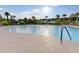 Large community pool surrounded by palm trees, lounge chairs, and a beautiful blue sky at 118 Billowing Sails St, Summerville, SC 29486