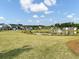 Scenic community view with a pond, palm trees, manicured lawn, and attractive modern homes at 1226 Spotflower St, Summerville, SC 29485