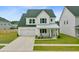 Inviting two-story home with a well-kept lawn, attached garage, and a charming front porch at 1226 Spotflower St, Summerville, SC 29485
