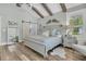 Stylish bedroom with wood-look floors, beamed ceiling, a ceiling fan, and a sliding barn door to the en-suite bathroom at 1245 Saddlehorn Rd, Summerville, SC 29486