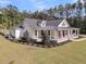Angle view of this home with a large porch, white columns, and landscaped front yard at 1245 Saddlehorn Rd, Summerville, SC 29486