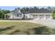 Side view of a white home featuring a three-car garage and lush landscaping at 1245 Saddlehorn Rd, Summerville, SC 29486