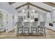 Modern kitchen island with seating, featuring white cabinets and a view into an adjoining room at 1245 Saddlehorn Rd, Summerville, SC 29486