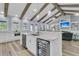 Island kitchen with white cabinets, stainless appliances, and wooden beams overlooking the living room at 1245 Saddlehorn Rd, Summerville, SC 29486
