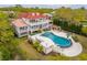 Aerial view of a sprawling home with a red roof, multiple balconies, a large pool, and lush landscaping at 13 Broughton Rd, Charleston, SC 29407