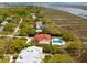 Stunning aerial view of a luxurious home with a red roof, inviting pool, and lush landscaping in a beautiful neighborhood at 13 Broughton Rd, Charleston, SC 29407