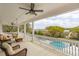 Spacious back porch with rocking chairs and a view of the pool, waterfront, and lush trees at 13 Broughton Rd, Charleston, SC 29407
