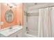 A bathroom featuring patterned wallpaper, a round decorative mirror, and a tub with white subway tile surround at 13 Broughton Rd, Charleston, SC 29407