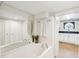 Bathroom showcasing a soaking tub, large mirror, and unique round window overlooking a sink with dark counters at 13 Broughton Rd, Charleston, SC 29407