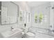 Bright, all-white bathroom with a large shower and tub, complemented by shuttered windows at 13 Broughton Rd, Charleston, SC 29407