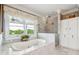 Luxurious primary bathroom featuring a marble soaking tub under a window and a separate tiled shower with glass surround at 13 Broughton Rd, Charleston, SC 29407