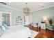 Charming bedroom with a decorative light fixture, hardwood floors, and bright blue walls at 13 Broughton Rd, Charleston, SC 29407