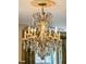 Close-up view of an ornate crystal chandelier with candle-style lights and intricate details at 13 Broughton Rd, Charleston, SC 29407