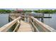 Wooden dock walkway featuring railings, a boat lift, and a covered structure in the background at 13 Broughton Rd, Charleston, SC 29407