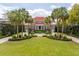 Impressive brick home with meticulously manicured landscaping, symmetrical palm trees, and a circular driveway at 13 Broughton Rd, Charleston, SC 29407