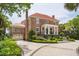 A brick home features a three-car garage, mature landscaping, and a classic architectural style at 13 Broughton Rd, Charleston, SC 29407