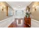 The foyer features gleaming hardwood floors, decorative wallpaper, and ornate lighting for a grand entrance at 13 Broughton Rd, Charleston, SC 29407