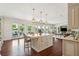 Open concept kitchen with island, hardwood floors, view of living area, and doors to patio at 13 Broughton Rd, Charleston, SC 29407