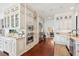 A spacious and well-lit kitchen with white cabinets, stainless appliances and beautiful hardwood flooring at 13 Broughton Rd, Charleston, SC 29407