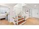 Bright staircase features wood treads, white risers, and railing leading to an open doorway with a bedroom visible at 13 Broughton Rd, Charleston, SC 29407