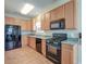 Well-lit kitchen featuring wooden cabinets, black appliances, and laminate flooring at 132 Lynches River Dr, Summerville, SC 29485
