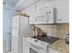 Compact kitchen featuring white cabinets, stainless appliances, and a decorative tile backsplash at 1332 Pelican Watch Villas, Seabrook Island, SC 29455