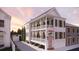 Stunning two-story home with a balcony and beautiful white siding and a quaint front door at 134 Spring St, Charleston, SC 29403