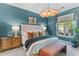 Comfortable bedroom with turquoise walls, large windows, and decorative lighting fixture at 137 Low Tide Ct, Charleston, SC 29492