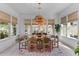 Bright dining room with a rustic chandelier, large windows, and seating for six at 137 Low Tide Ct, Charleston, SC 29492