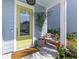 Inviting front porch with a bright yellow door, bench, and potted plants at 137 Low Tide Ct, Charleston, SC 29492