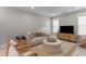 Bright living room with a comfortable sofa, rattan chairs, an ottoman, and a media cabinet at 137 Low Tide Ct, Charleston, SC 29492