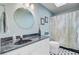 A modern bathroom featuring a sleek vanity, a round mirror, and a shower with a patterned curtain at 1391 Southlake Dr, Mount Pleasant, SC 29464