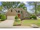 Charming brick home featuring a manicured lawn, colorful flowerbeds, and an inviting red front door at 1391 Southlake Dr, Mount Pleasant, SC 29464