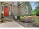 Inviting red front door with brick steps and lush landscaping, creating a warm and welcoming entrance at 1391 Southlake Dr, Mount Pleasant, SC 29464