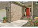 Close-up of the front door and entryway to a brick home with a vibrant red door and tidy landscaping at 1391 Southlake Dr, Mount Pleasant, SC 29464
